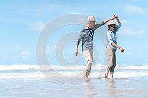 Asian couple senior elder dancing retirement resting relax at sunset beach