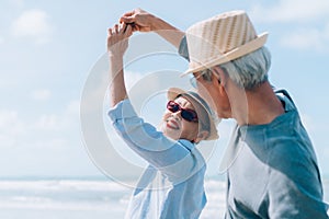 Asian couple senior elder dancing retirement resting relax at sunset beach honeymoon