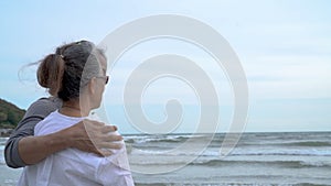 Asian couple senior elder retire resting hugging at sunset beach honeymoon family