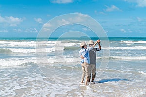 Asian couple senior elder retire resting relax dancing at sunset beach