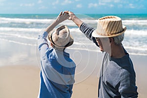 Asian couple senior elder retire resting relax dancing at sunset beach honeymoon