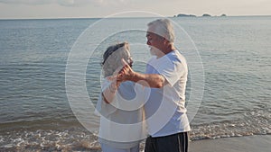 Asian couple senior elder retire resting relax dancing at sunset beach honeymoon family together