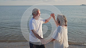 Asian couple senior elder retire resting relax dancing at sunset beach honeymoon family together