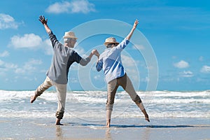 Asian couple senior elder retire resting relax at sunset beach