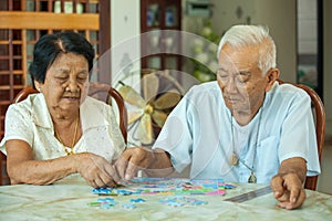 Asian couple senior playing with a jigsaw puzzle