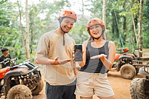 asian couple showing the blank phone to the camera