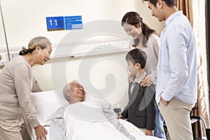 Asian couple and son visiting grandfather and grandmother in hospital