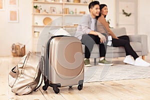 Asian Couple With Suitcase Waiting Sitting On Couch At Home