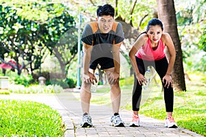 Asian couple take breathless break from running