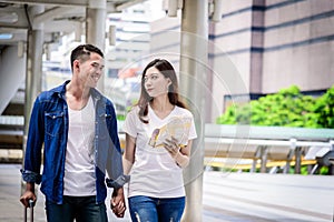 Asian couple tourist has walking and travelling with big purple