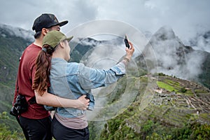 Asian couple tourist taking selfie at Machu Picchu