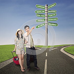 Asian couple travel with road signs outdoor