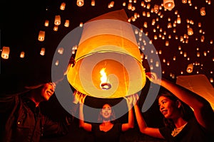 Asian couple traveller setting yi peng lantern in loi krathong festivities