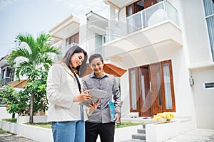 Asian couple using pads and clipboards in a residential background photo