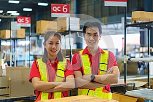 Asian couple warehouse worker smiling and arm cross at counter already preparation container box goods deliverly to customer