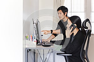 Asian couple working on computer together at home.