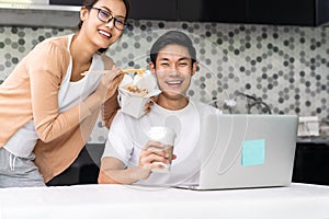 Asian couple working from home with take out food