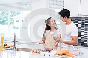 Asian couples cooking and baking cake together in kitchen room a