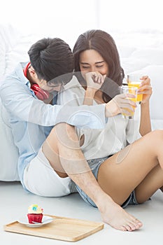Asian couples drinking a glass of orange juice