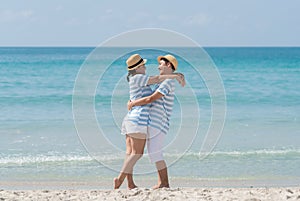 Asian couples are embracing each other and looking at each other happily on the beach