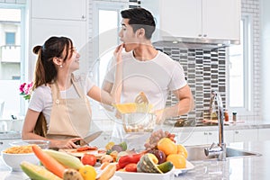 Asian couples feeding food together in kitchen. People and lifestyles concept. Sweet honeymoon and Holidays concept. Valentines d