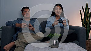 Asian couples are having fun playing games in their living room at night