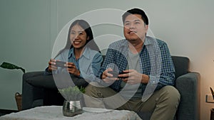 Asian couples are having fun playing games in their living room at night