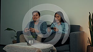 Asian couples are having fun playing games in their living room at night