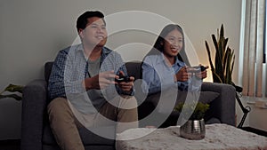 Asian couples are having fun playing games in their living room at night