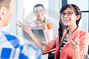 Asian creative agency workers discussing