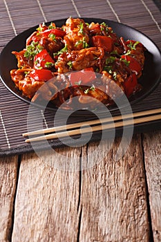Asian cuisine: Pork with sauce with vegetables on a plate. vertical
