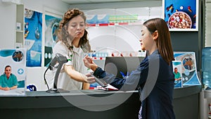 Asian customer paying for medicaments with smartwatch at pharmacy counter