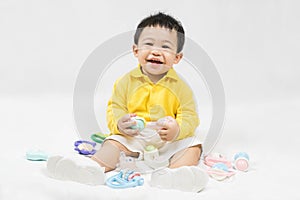 Asian cute baby boy about one year old in yellow shirt playing educational toys have fun smile and laugh happily isolated on white