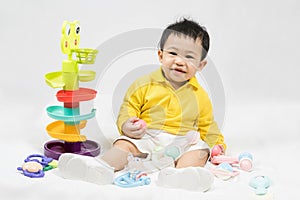 Asian cute baby boy about one year old in yellow shirt playing educational toys have fun smile and laugh happily isolated on white