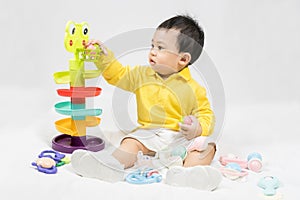 Asian cute baby boy about one year old in yellow shirt playing educational toys have fun smile and laugh happily isolated on white