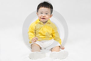 Asian cute baby boy about one year old in yellow shirt sitting and  smile isolated on white Selective focus