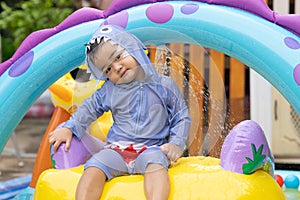 Asian cute baby boy playing in inflatable baby pool