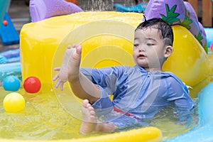 Asian cute baby boy playing in inflatable baby pool