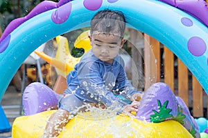 Asian cute baby boy playing in inflatable baby pool