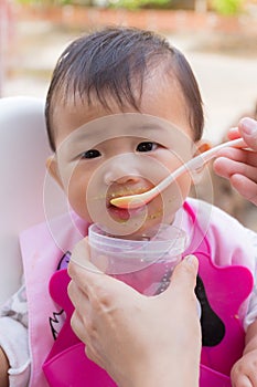 Asian cute baby eating food.