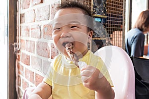 Asian cute baby eating grilled lamb meat & x28;should rack