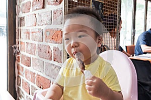 Asian cute baby eating grilled lamb meat & x28;should rack