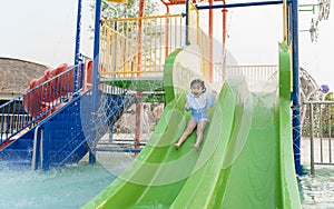 Asian cute baby girl daughter laughing happy and swimming playing slide pool in the pool at the resort, smiling and laughing.