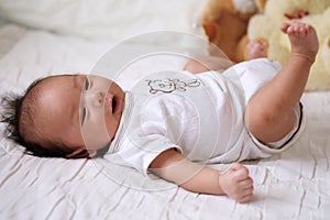Asian cute baby newborn smile and happy, good mood, on the bed with milk bottle