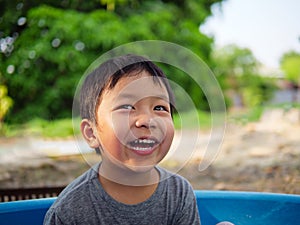 Asian cute child boy smiling and laughing with whitening teeth in nature background