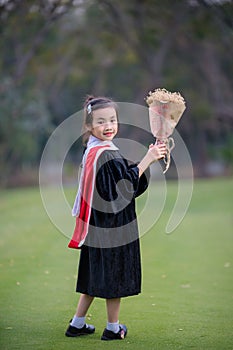 Asian cute child girl graduate. Girl smile on graduation kindergarten uniform