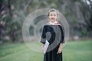 Asian cute child girl graduate. Girl smile on graduation kindergarten uniform