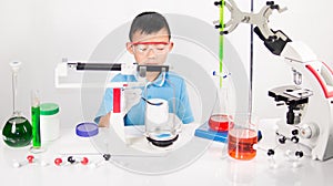 Asian cute child learning science in laboratory on gray whit background.