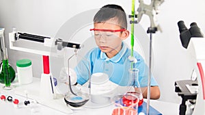 Asian cute child learning science in laboratory on gray whit background.