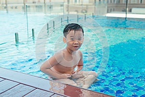 Asian cute child swimming in swimming pool. He playing is funny